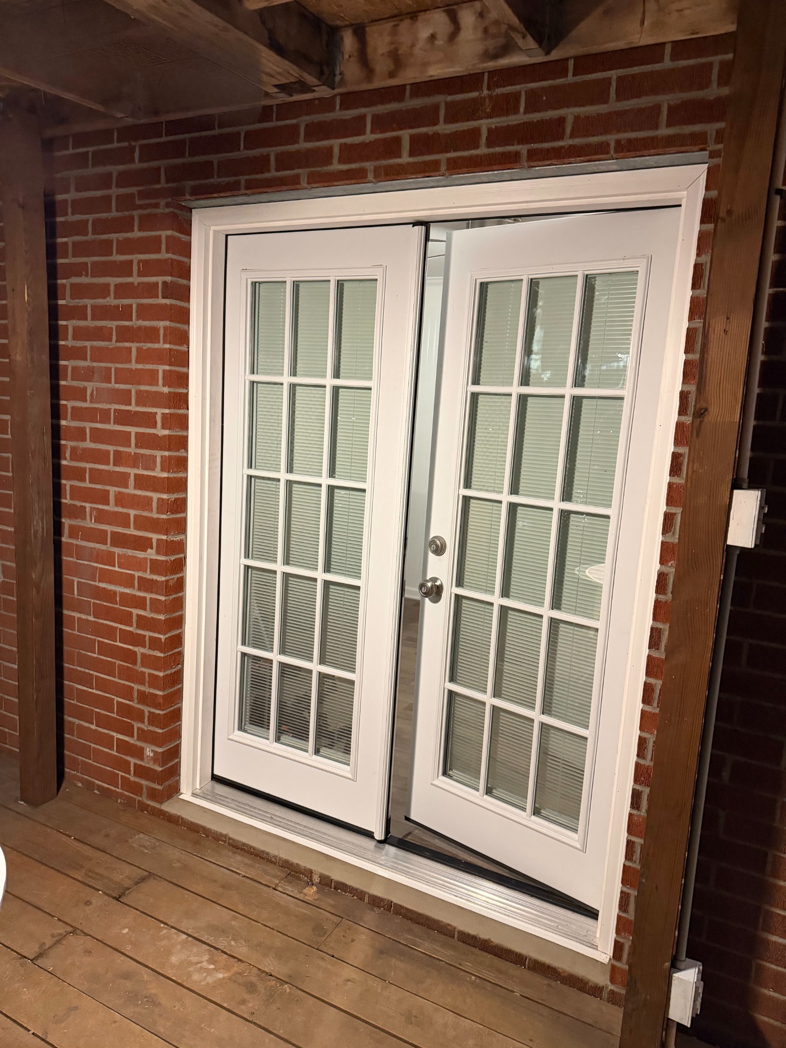 White French doors installed in the enlarged brick opening